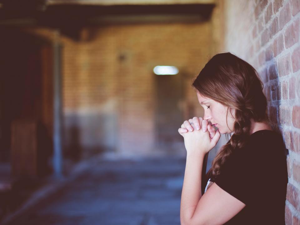 girl praying in room